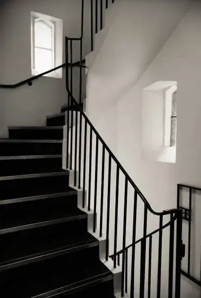 Classic black iron stair railing with slender pickets in a stairwell