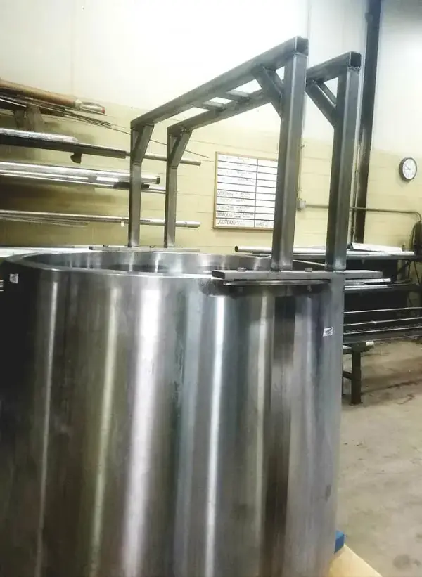 Stainless steel tank with a welded tubular support frame in a processing plant